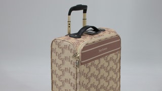 Ein beigefarbener Rollkoffer der Marke "Juicy Couture" in einer Größe von 70 x 46 x 25 cm.
