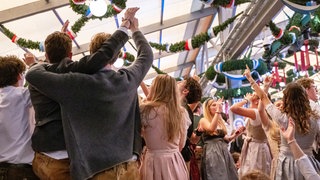 Besucherinnen und Besucher feiern auf einem Volksfest.