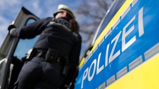 Nahaufnahme von Polizeiauto mit Polizistin