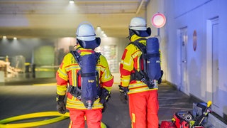 Zwei Feuerwehrleute im Einsatz. In einem Einkaufszentrums in Filderstadt hat es im Außenbereich gebrannt.