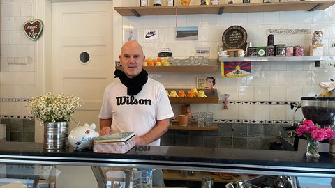 Der Gastronom steht hinter seiner Theke.