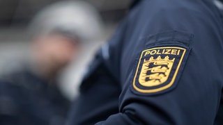 Ein Polizist und eine Polizistin der Polizei Baden-Württemberg stehen in einem Industriegebiet. Die Polizei hat vier Jugendliche wegen einer Einbruchsserie festgenommen.