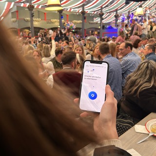 Mehr Sicherheit im Festzelt: Auf dem Stuttgarter Frühlingsfest bieten alle Festwirte den Besucherinnen und bescuhern die Sicherheits-App "SaveNow" an.