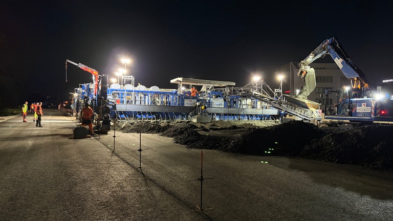 A81-Ausbau: Unterbeton wird in einen Trichter geschaufelt.