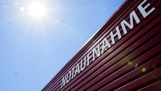 Schild einer Notaufnahme auf das die Sonne scheint.
