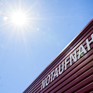 Schild einer Notaufnahme auf das die Sonne scheint.
