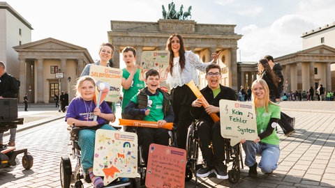 Bei der Auftaktversanstaltung des Kinder-Lebens-Laufs stehen Kinder zusammen vor dem Brandenburgertor in Berlin.