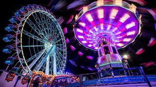 Das Kettenkarussell und Riesenrad auf dem Cannstatter Volksfest bei Nacht. Am 25. September startet das 179. Cannstatter Volksfest auf dem Wasengelände in Stuttgart.