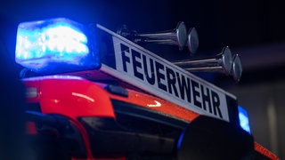 ein Einsatzfahrzeug der Feuerwehr mit Blaulicht (Symbolbild)