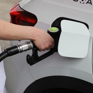 Eine Frau steht an einer Tankstelle und tankt ihr Auto. Symbolbild zu hohen Dieselpreisen