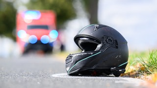 Der Helm eines Motorradfahrers liegt nach einem Unfall auf der Straße. (Symbolbild)