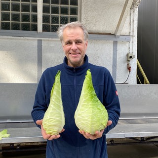 Landwirt Jörg Kimmich mit zwei Filderspitzkrautköpfen