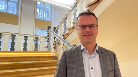 Oberbürgermeister Stephan Neher von der CDU im Treppenhaus des Rottenburger Rathauses. Er kritisiert Kanzlerkandidat Friedrich Merz von der CDU scharf für dessen Zusammenarbeit mit der AfD.