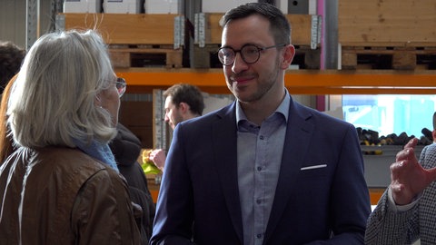 Christoph Naser spricht bei einer Wahlkampfveranstaltung mit einer älteren Frau. Er möchte für die CDU das Direktmandat im Wahlkreis Tübingen holen.