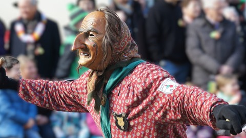 Die Stadthexe der Narrenzunft Rottenburg mit geschnitzer Holzmaske, Kopftuch und Hexenkittel. auch sie sind am Schmotzigen im Einsatz.
