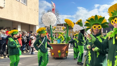 Als Sonnenblumen verkleidete Narren auf der Straße in Rottenburg. Sie nennen sich Bettsoicher.