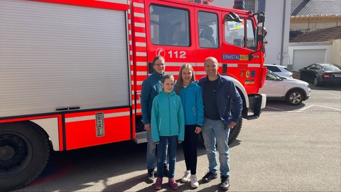 Martin Salzer mit seiner Frau und seinen beiden Töchtern vor dem Feuerwehrauto, das er in die Ukraine bringt.