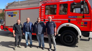 Martin Salzer und Simon Nowotni zusmmen mit zwei Feuerwehrmänndern von Kirchheim Teck vor einem der Feuerwehrautos, die sie gemeinsam in die Ukraine fahren.