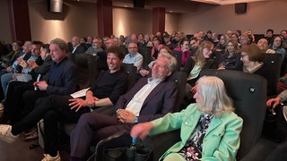 Boris Palmer im Kinosaal in Tübingen bei der Preview der SWR-Doku über ihn: "Der Palmer Komplex". Direkt neben ihm sitzt seine Mutter Erika und der Filmautor Frank Marten Pfeiffer.