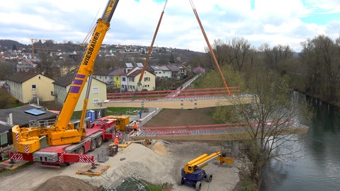 In Tübingen-Lustnau wird eine neue Rad- und Fußgängerbrücke über den Neckar eingesetzt.