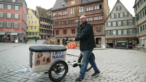 Lastenrad mit Mann wird über Tübinger Marktplatz geschoben