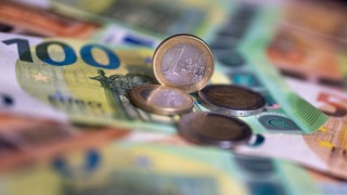 Münzen liegen auf Geldscheinen. Tübinger Haushalt nicht genehmigt. Das Regierungspräsidium fordert Nachbesserungen.