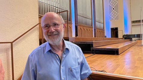 Harald Lesch lächelt am Rand der Bühne im Festsaal der Universität Tübingen. Zuvor hat er bei seinem Vortrag im Rahmen der Mediendozentur zum "analogen Widerstand" aufgerufen.