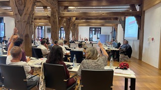 Gemeinderatssitzung in Tübingen: Ein paar Räte heben die Hand. Der Gemeinderat hat entschieden, dass die Grund- und Gewerbesteuer erhöht werden.