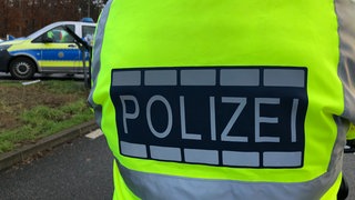 Ein Polizist von hinten: Ein Mann ist bei Gartenarbeiten in Pfullingen tödlich verunglückt. (Symbolbild)