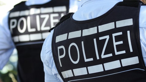 Symbolbild: Zwei Westen mit der Aufschrift "Polizei". Nach einem Angriff auf Bauarbeiter in Burladingen ist ein zweiter Mann in U-Haft.