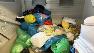 In der Kleiderkammer des DRK Tübingen - viele Plastiksäcke liegen quer übereinander. Das DRK meint, die Altkleidersammlung lohne sich inzwischen nicht mehr. 