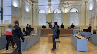 Vor der Urteilsverkündung geht die Angeklagte Mutter zur Anklagebank. Sie hatte ihr neugeborenes Baby in die Waschmaschine gesteckt. Das Baby ist gestorben. Jetzt muss sie fünfeinhalb Jahre ins Gefängnis.