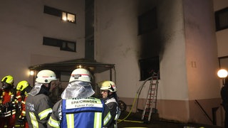 Einsatzkräfte der Feuerwehr löschen einen Brand in einem Mehrfamilienhaus. In Rietheim-Weilheim im Kreis Tuttlingen eilen am Abend zahlreiche Rettungskräfte zu einem Brand.