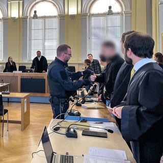 Gerichtssaal im Landgericht Hechingen. Angeklagte, Verteidiger, Kläger und Richter stehen an ihren Plätzen. Im Entführungsprozess hat das Opfer ausgesagt.