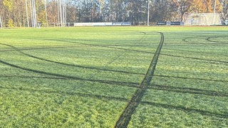 Sportplatz in Mössingen-Belsen mit deutlichen Auto-Spuren, die kreisförmig und gerade über den Rasen verlaufen. Die Stadt will den Platz günstiger sanieren als ursprünglich gedacht.