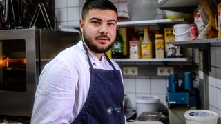 Ein junger Mann steht mit einer Schürze in einer Großküche. Der Asylbewerber Hussain Salan hat im Hechinger Refugio als Koch gearbeitet (Archivbild).