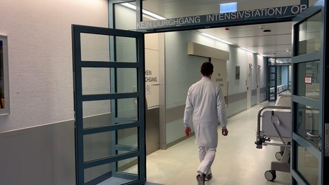 Ein Arzt der BG Klinik Tübingen läuft auf einem Flur der Intensivstation. Er hat zwei der Brandopfer aus Crans-Montana behandelt. 