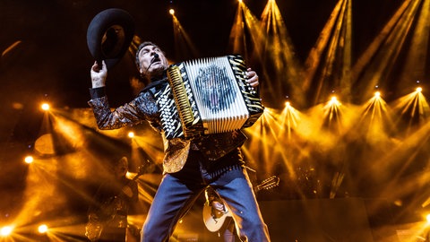 Im goldenen Bühnenlicht spielt Eduardo Hernandez Akkordeon