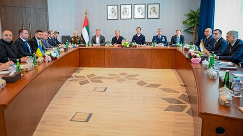 Vertreter:innen von Russland und Ukraine in einem Besprechungsraum in Abu Dhabi. Die USA vermitteln.