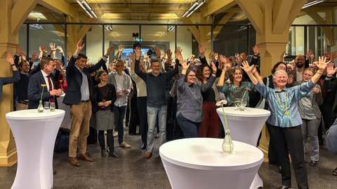 Mitarbeiter der Uni Tübingen jubeln bei der Bekanntgabe, dass die Universität Tübingen Exzellenzuni bleibt. Damit bekommt die Uni weiterhin Fördermittel in Millionenhöhe.