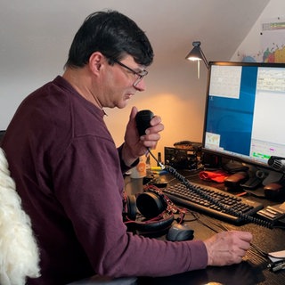 Amateurfunk als Hobby: Denis Mrša aus Balingen hat Funk-Mikrofon in der Hand und versucht mit jemandem in der Ferne zu sprechen.