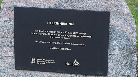 Eine schwarze Gedenktafel auf einem Stein mit der Aufschrift "In Erinnerung". Im Stillen Gedenken wurde zum Jahrestag der Verunglückten Bauarbeiter der Horber Hochbrücke gedacht.