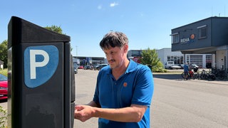 Der Physiotherapeut Hartmut Schölkopf an einem Parkautomat im Tübinger Gewerbegebiet Au-Ost.