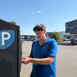 Der Physiotherapeut Hartmut Schölkopf an einem Parkautomat im Tübinger Gewerbegebiet Au-Ost.