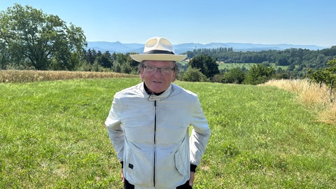 Werner Mehlhorn steht auf einer Wiese bei Nürtingen und hat einen hellen Hut sowie eine Jacke an. So schützt er sich gegen zecken.