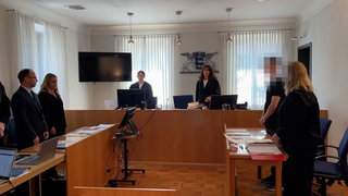 Mehrere Menschen stehen in einem Sitzungsaal des Amtsgerichts Balingen. Ein 33-Jähriger musste sich verantworten, weil er einen schweren Unfall bei Haigerloch ausgelöst haben soll.
