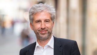 Boris Palmer, der parteilose Oberbürgermeister von Tübingen, lächelt in die Kamera.
