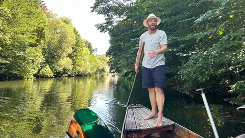 Jonas Hörrmann steht auf einem Stocherkahn im Neckar in Tübingen