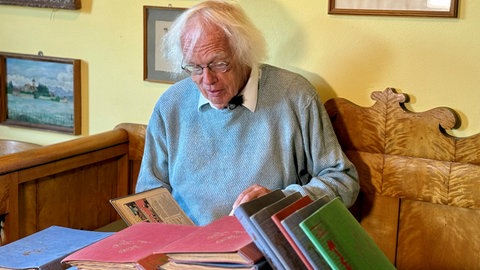 Micky-Maus-Sammler Ernst Heimes stöbert in seiner Kollektion. Er hat in seiner Kindheit die ersten 150 Ausgaben der Zeitschrift gesammelt.