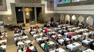 Ein Blick von oben in den Saal der Pauluskirche in Ulm. An den aufgebauten Tischen der Vesperkirche können Bedürftige für kleines Geld kostenlos essen.